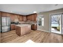 Bright, renovated kitchen featuring a center island, wooden cabinets, and modern stainless steel appliances at 853 Mockingbird St, Brighton, CO 80601