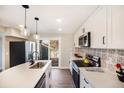 The remodeled kitchen features white cabinets, stainless appliances, and a door to the backyard deck at 909 Reynolds Farm Ln # C2, Longmont, CO 80503