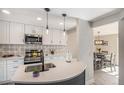 Lovely remodeled kitchen features white cabinetry, stainless appliances, quartz counters, and stylish backsplash at 909 Reynolds Farm Ln # C2, Longmont, CO 80503