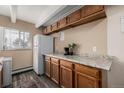 Kitchen with wooden cabinets, granite countertops, stainless steel appliances, and a bright window at 1180 Yosemite St # 104, Denver, CO 80220