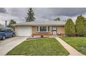 Cozy home with brick facade, green lawn, and attached garage, a welcoming front entrance at 3751 W 85Th Ave, Westminster, CO 80031
