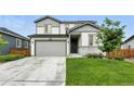 Charming two-story home featuring a well-maintained lawn, gray siding, and an attached two-car garage at 6513 Dry Fork Cir, Frederick, CO 80516
