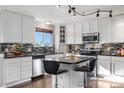 Well-equipped kitchen featuring granite countertops, stainless steel appliances, and barstool seating at the island at 5997 S Yakima St, Aurora, CO 80015