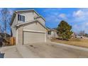 View of a two-story home with a two-car garage and a well-maintained lawn on a sunny day at 465 S 24Th Ave, Brighton, CO 80601