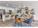 Well-lit kitchen with white cabinets, granite countertops, a breakfast bar, and a dining area, perfect for modern living at 4021 S Teller St, Lakewood, CO 80235