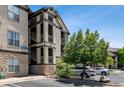 Three-story condo building with private balconies, reserved parking, and surrounding trees at 7422 S Quail Cir # 1624, Littleton, CO 80127