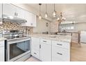 Modern kitchen boasting white cabinets, granite countertops, stainless steel appliances, and stylish pendant lighting at 200 Primrose Path # 11, Breckenridge, CO 80424