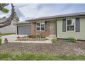 Close-up of home exterior with brick facade, well-kept garden bed, and paved driveway at 5925 W 86Th Ave, Arvada, CO 80003