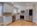 Modern kitchen featuring stainless steel appliances, white cabinets and granite countertops at 5925 W 86Th Ave, Arvada, CO 80003