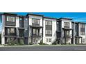Modern townhome exterior showcasing gray and white color schemes, with balconies and well-maintained landscaping at 688 Belay St, Erie, CO 80516