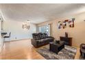Bright living room featuring a cozy fireplace, hardwood floors, and sliding door access to a patio at 14130 E Temple Dr # T01, Aurora, CO 80015