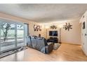 Open living room with hardwood floors, a sliding glass door, and stylish decor at 14130 E Temple Dr # T01, Aurora, CO 80015