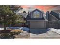 Charming two-story home with well-manicured lawn, two-car garage, and classic architectural details at sunset at 5421 E Prescott Ave, Castle Rock, CO 80104