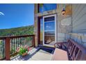 Inviting front porch featuring stone accents, a bench, and scenic mountain views at 1295 Hy Vu Dr, Evergreen, CO 80439