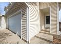 Close-up of garage and front door of townhouse featuring neutral siding and manicured lawn at 892 Macaw St, Brighton, CO 80601