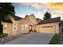 Charming home featuring a stone facade, two-car garage, and manicured landscaping at 6524 Surry Pl, Parker, CO 80134