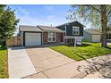 Inviting exterior view of a two-story home, with a lush lawn and a paved driveway leading to an attached garage at 4512 S Yank St, Morrison, CO 80465