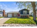 Charming two-story home with a brick facade, well-maintained lawn, and attached garage in a suburban neighborhood at 4512 S Yank St, Morrison, CO 80465