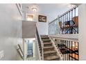 An elegant, carpeted staircase with black ornate iron spindles and white banisters creates a stunning focal point at 6280 S Colorado Blvd, Centennial, CO 80121