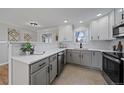 Bright kitchen featuring white cabinetry, stainless steel appliances, and elegant countertops at 1705 W Stoll Pl, Denver, CO 80221