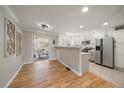 Open floor plan featuring a bright kitchen with stainless appliances connecting to a living area at 1705 W Stoll Pl, Denver, CO 80221