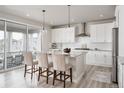 Modern kitchen features sleek white cabinetry, a granite island, and a sliding door to the outside at 7195 S Yantley Way, Aurora, CO 80016