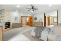 Serene main bedroom boasts a stone fireplace, neutral tones, and ensuite access, offering a tranquil retreat at 8662 Kim Ct, Parker, CO 80134