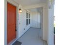 Inviting covered front porch with stylish orange door and ample space for seating and decor at 3074 Distant Rock Ave, Castle Rock, CO 80109