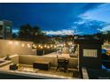 Enjoyable rooftop deck at dusk includes a gas grill, fire pit, and neighborhood view at 2922 W 26Th Ave # 4, Denver, CO 80211