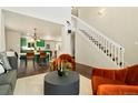 Bright living room featuring two-story ceilings, stylish seating, and an open floor plan at 11370 Iola St, Commerce City, CO 80640