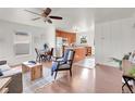 Bright, open-concept living area connects to a modern kitchen with hardwood floors and ample natural light at 1681 Nome St, Aurora, CO 80010