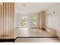 Bright entryway with modern light fixture, built-in bench, closet, and sleek wood floors at 4322 Quivas St, Denver, CO 80211
