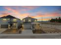Beautiful gray two-story home exterior illuminated by the vibrant hues of the sunset at 467 White Sand Trl, Castle Rock, CO 80104