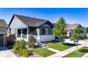 Charming two-story home with a cozy front porch, manicured lawn and beautiful landscaping at 15920 Buffalo Run Dr, Commerce City, CO 80022