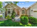 Front exterior with charming stone accents, wood door and manicured landscaping in the garden at 3145 Stevens Cir, Erie, CO 80516