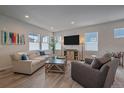 Bright living room with hardwood floors, comfy seating, and large TV at 10092 Flower St, Broomfield, CO 80021