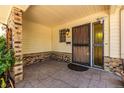 A welcoming front porch with brick accents and a sturdy, secure metal front door at 305 Titan St, Aurora, CO 80011