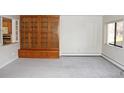 Open living area with built in wood shelving, neutral carpet, and large window offering lots of light at 14390 E Marina Dr # 104, Aurora, CO 80014