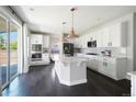 Bright, white kitchen features a center island, stainless steel appliances, and sliding glass doors to the outside at 15378 W 50Th Pl, Golden, CO 80403