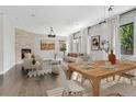 Bright living room and dining area with hardwood floors, a fireplace, and large windows at 15378 W 50Th Pl, Golden, CO 80403