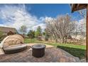 Private backyard with a cozy lounge area, fire pit, and lush green landscaping at 2369 Bayberry Ln, Castle Rock, CO 80104