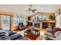 Living room with stone fireplace, vaulted ceiling, and large windows offering natural light and backyard views at 2369 Bayberry Ln, Castle Rock, CO 80104