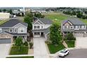 Aerial view of a suburban home with manicured lawn, surrounded by neighboring houses and green spaces at 8071 Tabor St, Arvada, CO 80005