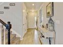 Bright entryway featuring wood-look floors, decorative accents, and a view of the staircase at 8071 Tabor St, Arvada, CO 80005