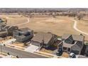 Aerial view of charming one-story home in rural neighborhood with large field in back at 1931 Marlowe W Cir, Erie, CO 80516