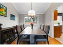 This dining room features a chandelier, large window, a wood table and seating for six at 1768 E Jamison Ave, Centennial, CO 80122