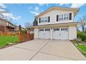 Attached two-car garage with white doors and adjacent to a well-maintained lawn and neutral colored siding at 1768 E Jamison Ave, Centennial, CO 80122