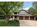 Charming home with meticulous lawn, mature trees, four car garage, and Tudor style architecture at 24 Spyglass Dr, Littleton, CO 80123