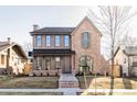 Stunning brick and wood two-story home featuring a charming front porch and architectural details at 1968 S Washington St, Denver, CO 80210