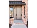 Beautiful wood front door flanked by brick accents and lantern-style lighting at 1968 S Washington St, Denver, CO 80210